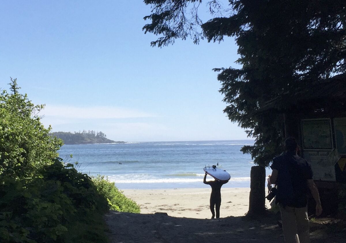 surfer-walking-to-beach-tofino-surf-town-british-columbia